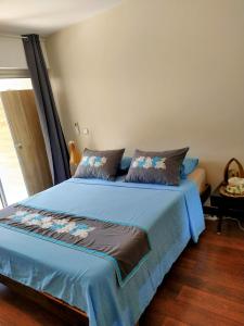 - une chambre avec un lit et une couette bleue dans l'établissement Farerei Appartement spacieux, équipé et confortable, à Fa'a'ā
