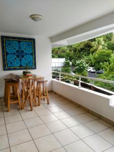 balcón con mesa y ventana grande en Farerei Appartement spacieux, équipé et confortable en Faaa