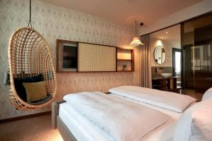 ein Schlafzimmer mit zwei Betten und einem Hängesessel in der Unterkunft Cocoon Sendlinger Tor in München + 90 Fotos