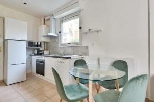 a kitchen with a glass table and green chairs at Superbe studio Vieux Nice 1 min à pied de la plage in Nice
