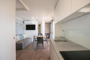 eine Küche und ein Wohnzimmer mit einem Tisch und einem Sofa in der Unterkunft Deluxe Beach Mobile Homes in Šibenik