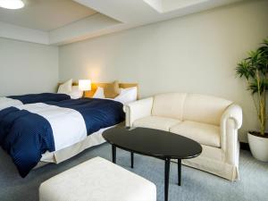 たつの市にあるLiVEMAX RESORT 瀬戸内 Sea Frontのベッドルーム1室(ベッド1台、ソファ、椅子付)