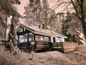 un autobús estacionado en el bosque en la nieve en Villa Mustikka, Messilä, en Tiirismaa