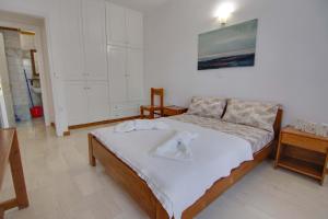 una camera da letto con un letto e due asciugamani di The Big Cypress Apartments ad Apólpaina