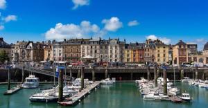 a group of boats docked in a harbor with buildings at Bienvenue chez Anaïs ! in Biville-sur-Mer