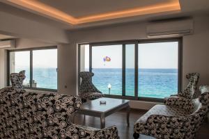 a living room with a couch and a view of the ocean at Sunrise Luxury Apartments Rhodes in Rhodes Town
