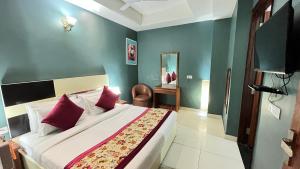 a bedroom with a large bed with red pillows at Qotel Hotel Church House Rohini Sector 15- Couple Freindly in New Delhi