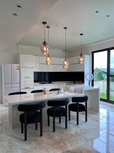 a kitchen with a large white island with black chairs at Lucid Dream清醒夢民宿 in Yilan City