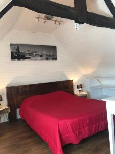 ein Schlafzimmer mit einem roten Bett im Dachgeschoss in der Unterkunft Chambres d'Hôtes de la Presqu'Île in Pleubian