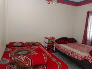 two beds in a room with red blankets at Kuakata Hotel & Resort in Kuākāta