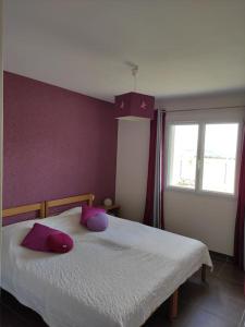 sypialnia z łóżkiem z fioletowymi ścianami i oknem w obiekcie Maison entière de plein pied avec vue panoramique. w mieście Venteuges