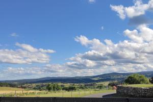 une route dans un champ avec un ciel aux nuages dans l'établissement Maison entière de plein pied avec vue panoramique., à Venteuges