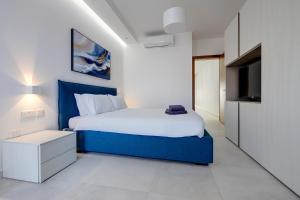 スリーマにあるSpectacular Apartment Valletta and Harbour Viewsのベッドルーム(青いベッド1台、テレビ付) +48枚の写真