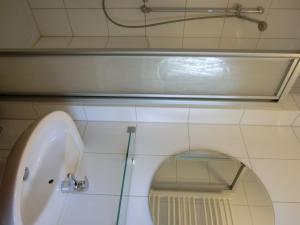 a bathroom with a white sink and a mirror at Ferienwohnung NH14 in Hirschburg