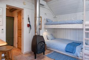 a bedroom with a bunk bed and a stove at Seaside Cottage Nr 3, Saltvik Hudiksvall in Hudiksvall