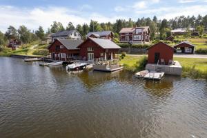 un gruppo di case sull'acqua vicino a un lago di Seaside Cottage Nr 3, Saltvik Hudiksvall a Hudiksvall