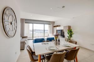 een eetkamer en een woonkamer met een grote klok aan de muur bij Luxe Apartment with Valletta and Harbour Views in Sliema