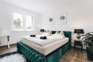 una camera con un grande letto e un divano verde di Stilvolle 4-Raumwohnung in zentraler Lage a Dresda