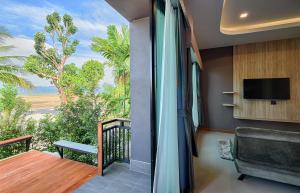 a room with a balcony with a view of the beach at Mangrovebay Krabi Beachfront Pool Villa in Ban Nai Sa