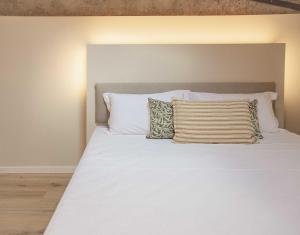 1 cama blanca grande con 2 almohadas en Corte Massimago, en Mezzane di Sotto