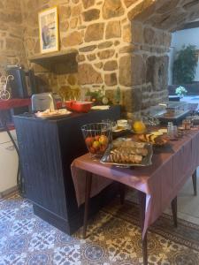 una cocina con una mesa con comida. en Chambres d'Hôtes de la Presqu'Île, en Pleubian