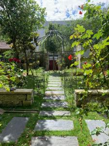 un jardín con invernadero y un camino de piedra en La laiterie de la Plume en Nantes