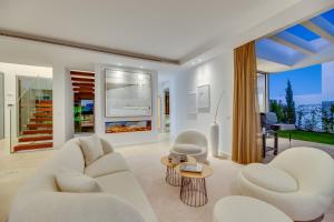 a living room with two white chairs and a table at VACATION MARBELLA I Villa Schumacher, New Built, Community, Private Pool in Estepona