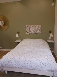 un letto in una camera da letto con due luci sul muro di La laiterie de la Plume a Nantes