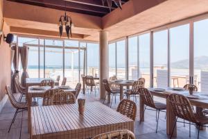 タリファにあるTarifa Lances by QHotelsの海の景色を望むテーブルと椅子付きのレストラン