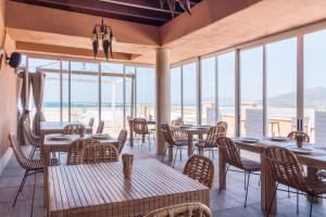 a restaurant with tables and chairs with a view of the ocean at Tarifa Lances by QHotels in Tarifa