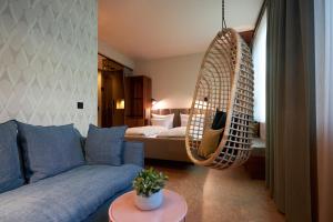 ein Wohnzimmer mit einem Sofa und einer hängenden Schaukel in der Unterkunft Cocoon Sendlinger Tor in München