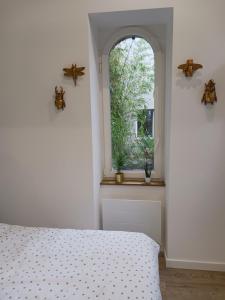 a bedroom with a bed and a window at La laiterie de la Plume in Nantes