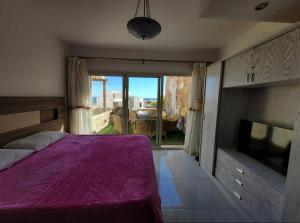 a bedroom with a purple bed and a tv at Luxury suite for rent in Sahl Hasheesh in Hurghada