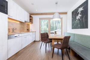 a kitchen with a table and chairs and a dining room at Franzerl in Tux