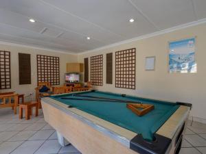 a living room with a pool table in it at Pebble Beach in Uvongo Beach