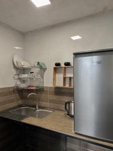 eine Küche mit einer Spüle und einem Kühlschrank in der Unterkunft Bách Xanh House. Triangle Bungalow in Tam Ðảo