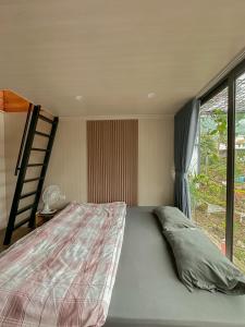 a bedroom with a bed and a large window at Bách Xanh House. Triangle Bungalow in Tam Ðảo