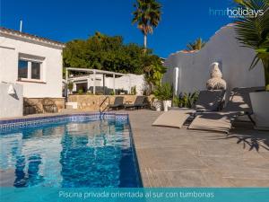 una piscina con sillas y una casa en Villa Serenity - HMR Holidays, en Moraira