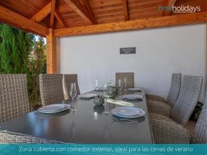 una mesa con platos y copas de vino. en Villa Serenity - HMR Holidays, en Moraira