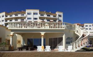 - un grand bâtiment blanc avec des chaises blanches devant dans l'établissement Stunning 4 Bedroom Beach Villa on Sandy Beach at Las Palmas Beach Resort V14 villa, à Puerto Peñasco