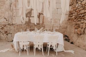 a white table with white chairs around it at N a k e d S o l in Manacor