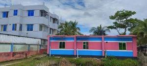 a colorful building next to a tall building at Kuakata Hotel & Resort in Kuākāta