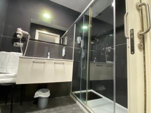 a bathroom with a glass shower and a sink at Gros City Apartments in San Sebastián