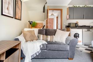 Una sala de estar con un sofá y una cocina. en New! Peaceful 4 Bed home - Quiet and Cosy, en Kent