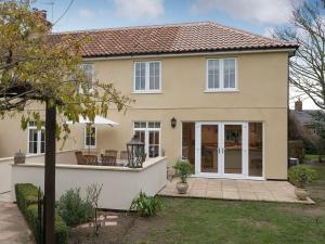 a detached house with a patio in a yard at Wisteria House in Henstead