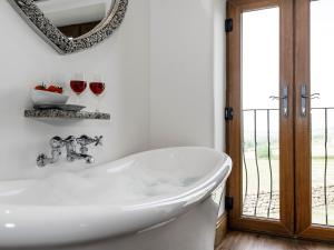 a bathroom with a tub and two glasses of wine at The Old Hat Factory in Scotforth