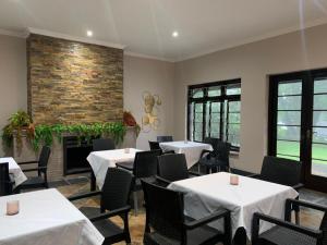 a dining room with tables and chairs and a fireplace at The Midlands Hotel in Pietermaritzburg