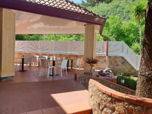 a patio with a table and chairs and a fence at Villa Eden in Corbara