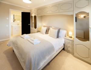 um quarto com uma grande cama branca com duas toalhas em The Masters by STAMP SA em Lytham St Annes