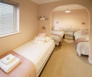 um quarto com três camas e um espelho em The Masters by STAMP SA em Lytham St Annes